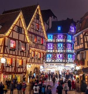 一群人走在挂满圣诞灯的城市街道上