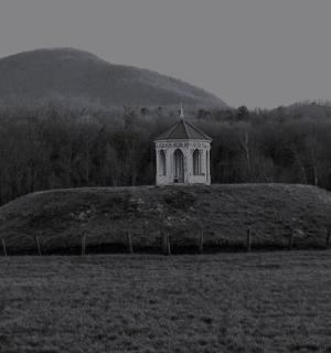 田野中的一座大山，山顶上有一座塔