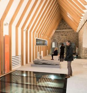 Muž stojí v muzeu s exponátem