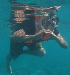 a woman in the water making a heart sign