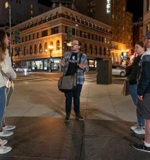 a group of people standing on a street at night