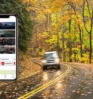 snímek obrazovky z mobilního telefonu, na kterém jede auto po silnici