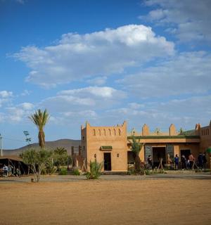 a building in the middle of a desert with palm trees