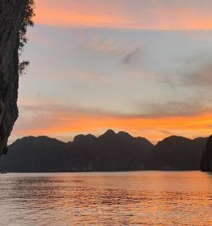 a sunset over a body of water with mountains