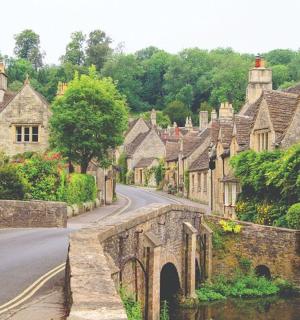 an old stone bridge in a village with houses