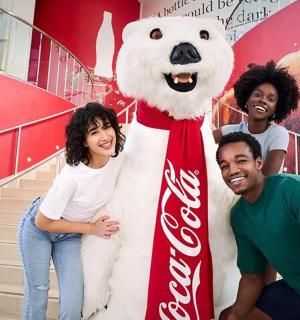 一群人站在一只可口可乐北极熊旁边