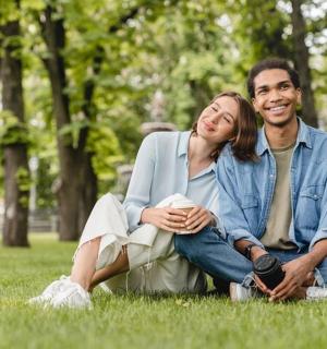 a man and a woman sitting on the grass