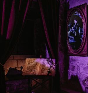 et mørkt rum med et billede af en person i et spejl