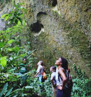 a group of people standing in front of a rock wall