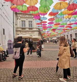 a group of people walking down a street under umbrellas