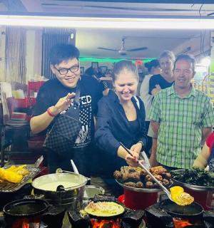 a group of people standing in a kitchen preparing food