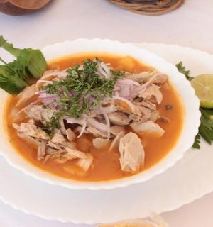 uma tigela de canja de galinha em um prato branco