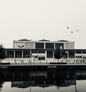 a building with birds flying over a body of water