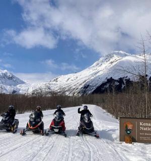 一群人在雪地里骑着雪地摩托