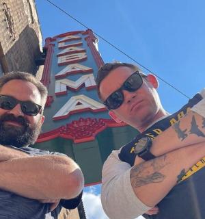 两名有纹身的男子站在标志牌前