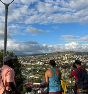 three people standing on top of a tower looking at a city