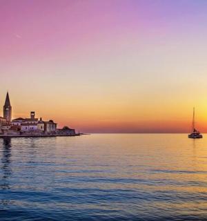 ein Sonnenuntergang über einer Stadt auf dem Wasser mit einem Boot