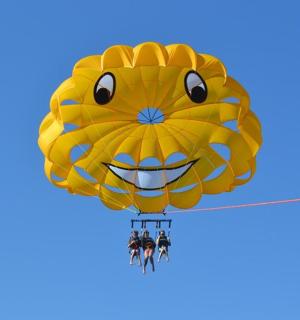 skupina lidí visících na žlutém padáku