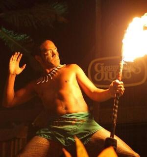 muž bez trička držící hořící pochodeň