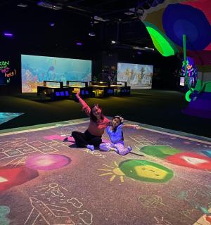 两个人坐在地板上，地板上有粉笔画