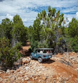 一辆蓝色吉普车沿着土路行驶