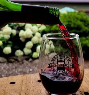 一个人把红酒倒进玻璃杯里