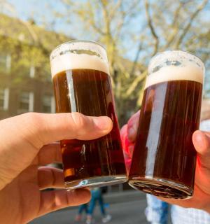 two people holding up glasses of beer