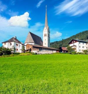 o biserică pe un deal cu un câmp verde