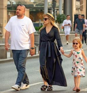 一名女子和一名男子带着一名小女孩走在街上