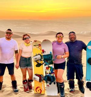 a group of people standing in the desert with snowboards
