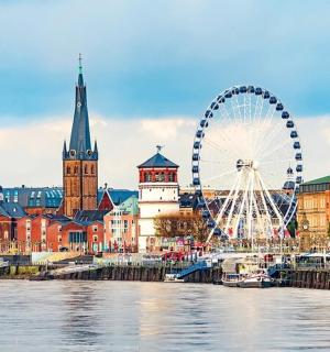 a city with a ferris wheel next to a river