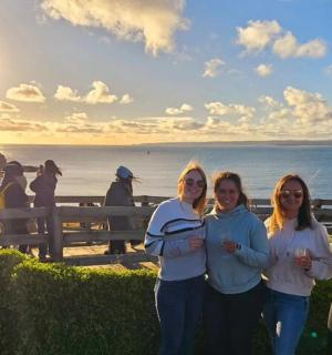 skupina žen stojících před oceánem