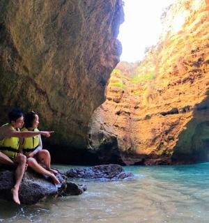 two people sitting on a rock in a cave