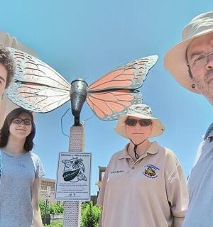 一群人站在蝴蝶雕像旁边