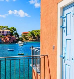 una porta a un balcó amb vistes a una massa d'aigua