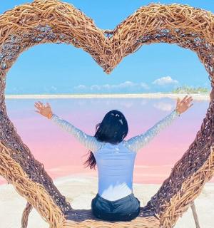 一位女士坐在椅子上，手里拿着一个心形的标志