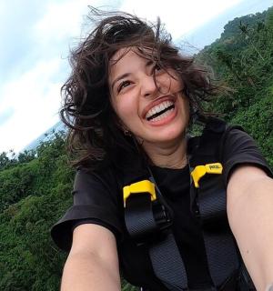 Žena se usmívá na kopci se žlutými motýlky