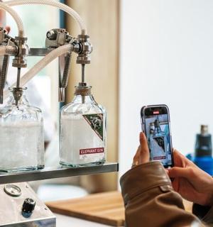 一位女士用手机拍摄瓶子的照片