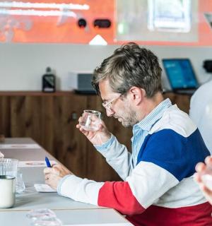 一位男士坐在桌边,一位女士手拿酒杯