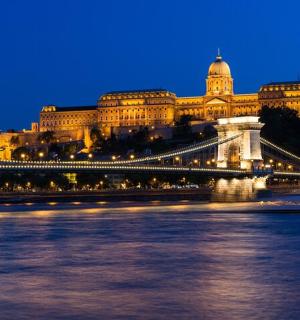 a bridge over a river in front of a large building
