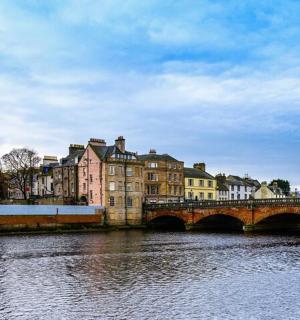 a bridge over a river with buildings and a church