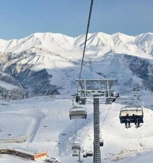 雪地里的两个人在滑雪缆车上