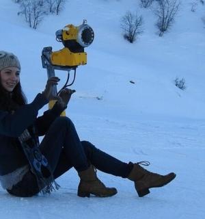 一名女子坐在雪地里,手里拿着滑雪板