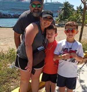 a woman and two boys posing for a picture at the beach