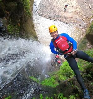muž ve žluté helmě překračující řeku