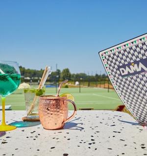 网球场上的一张桌子,上面放着饮料和一台笔记本电脑