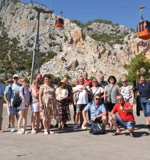 a group of people posing for a picture in front of a mountain