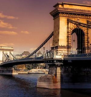 a bridge over a river with buildings in the background