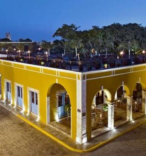 a yellow building with chairs on the roof