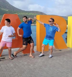 three men standing in front of a large php sign